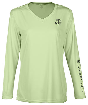 front view of a ladies olive green v-neck performance shirt with 90 Miles South Round left chest logo and right sleeve copy saying “90 Miles South”