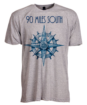 Front view of short sleeve heather grey tee shirt with blue artwork of 90 Miles South compass